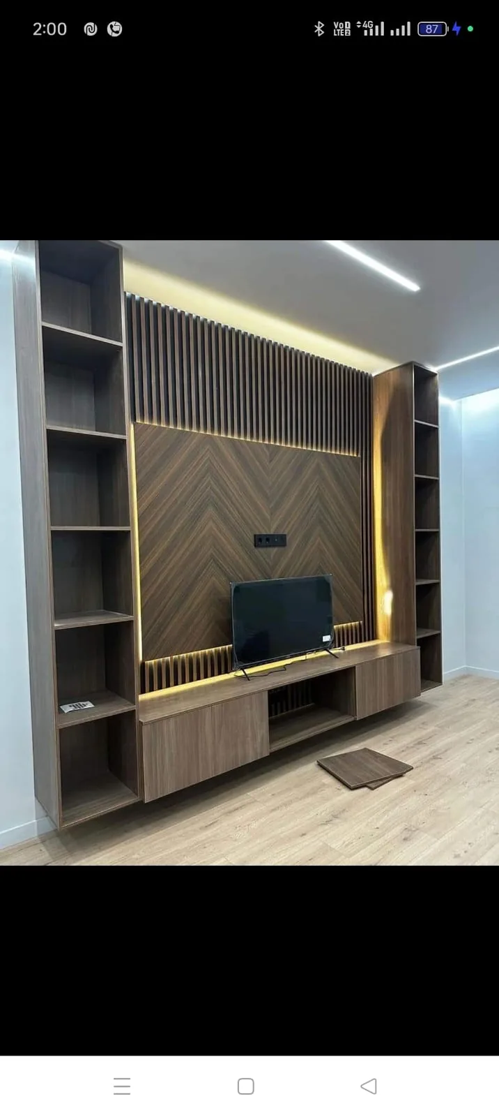 Walnut slat TV wall with side display shelves, floating storage and warm backlighting